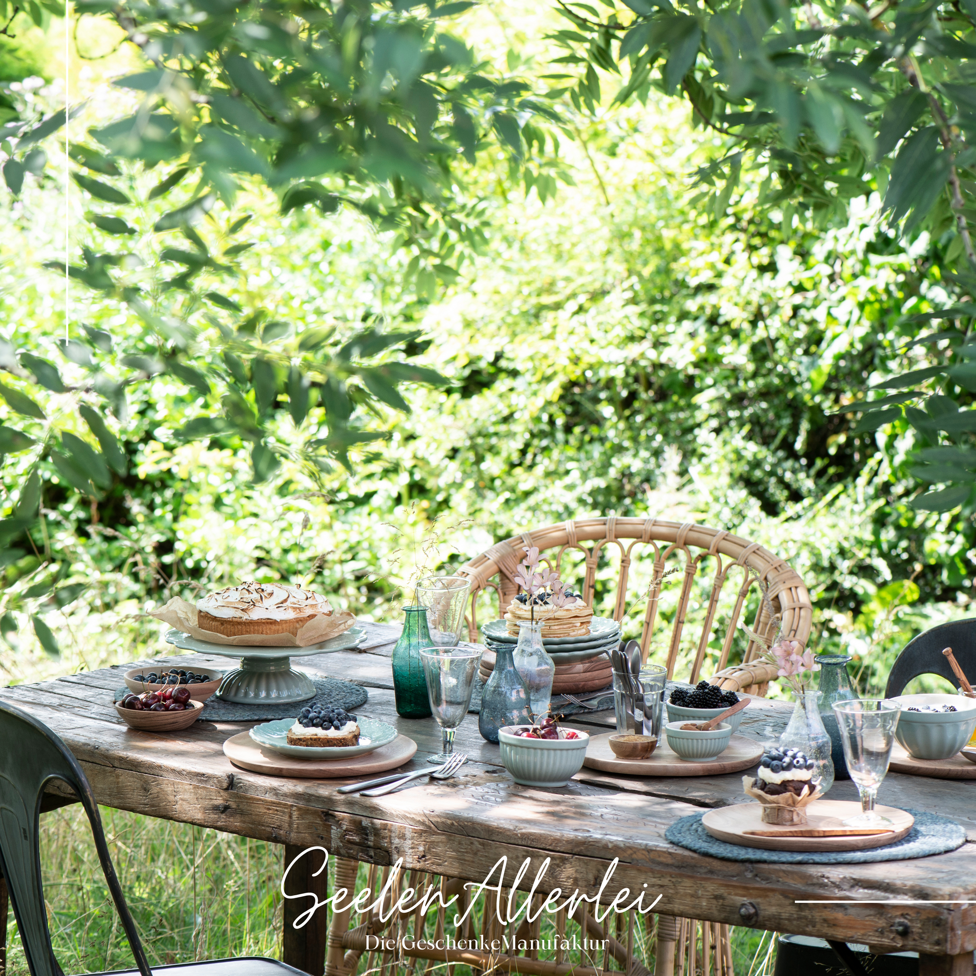 schön gedeckter Sommertisch mit Schalen Tellern und Tortenplatte von der Mynte Serie von IB Laursen in einem wunderschönen Garten
