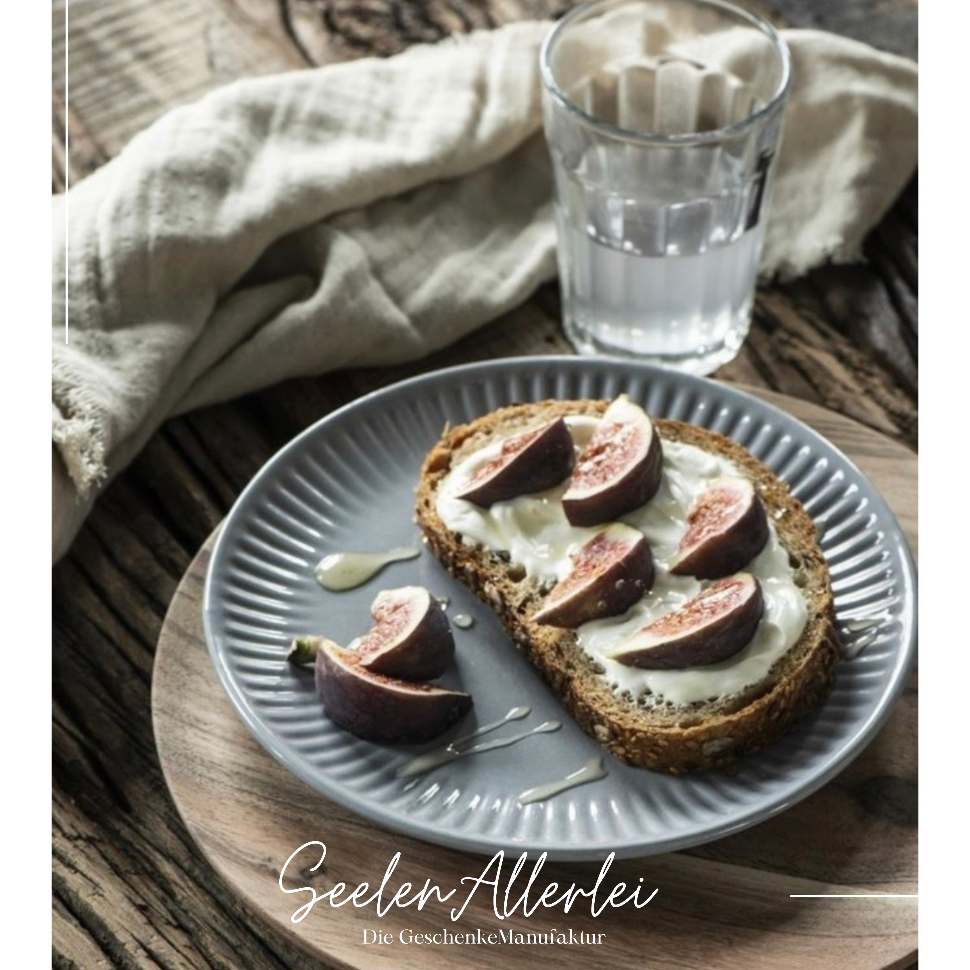 Butterbrot mit Frischkäse und Maracuja auf einem Teller mit Serviette und Glas